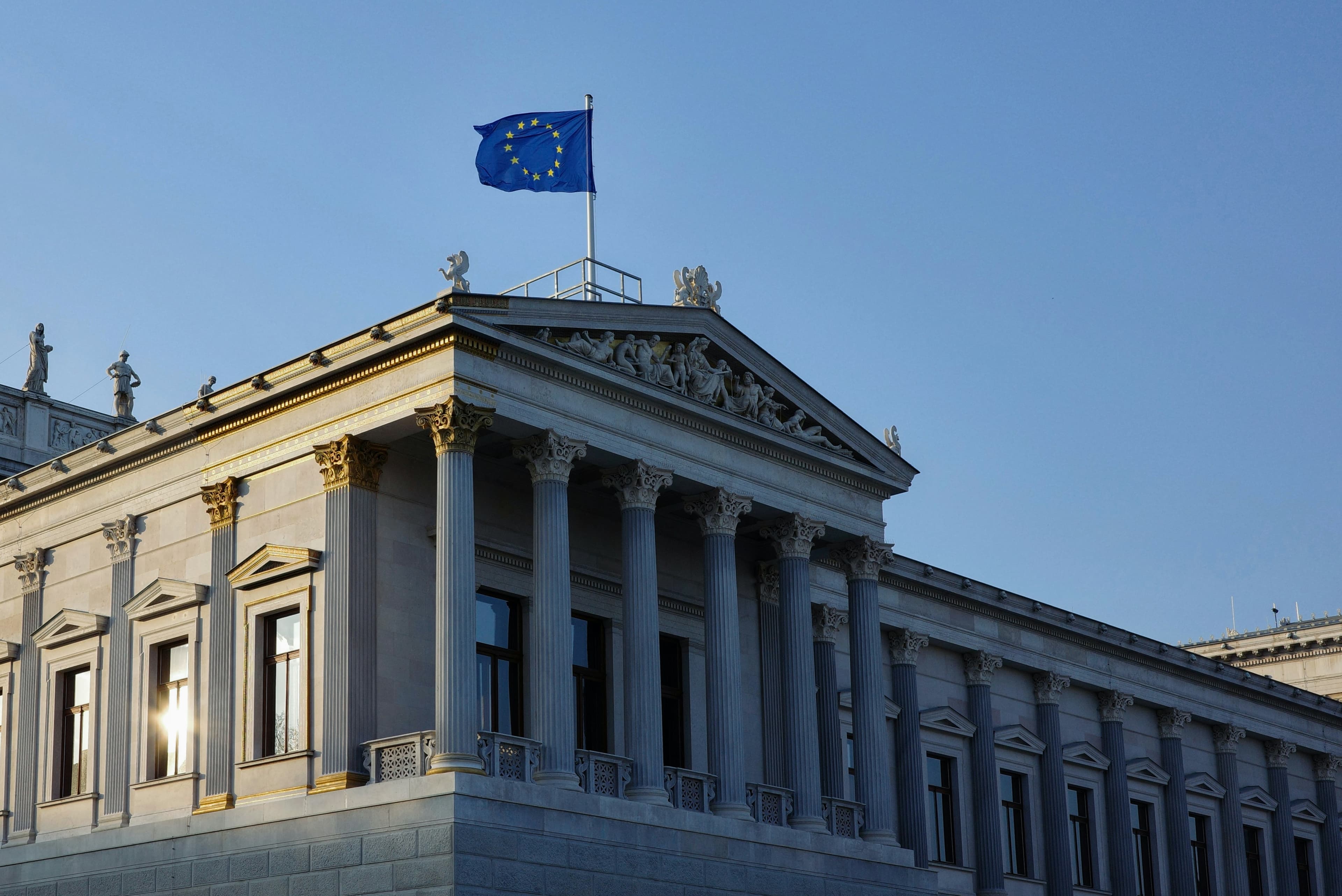 Trader monitoring digital asset markets with EU flag reflected in the window